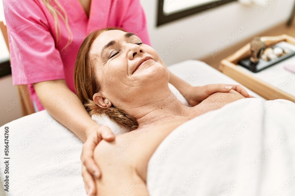 Sticker Middle age caucasian woman having shoulders massage at beauty center