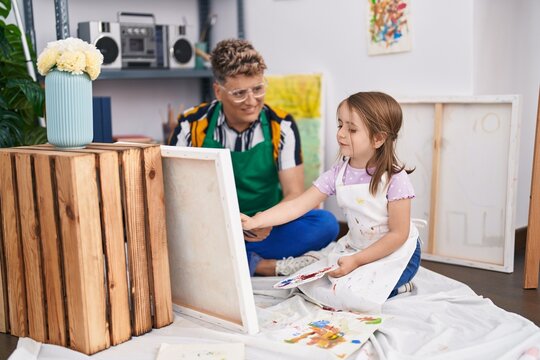 Father and daughter artists smiling confident drawing at art studio