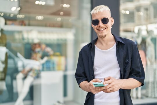 Young caucasian man smiling confident using smartphone at street