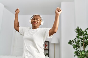 Fototapeta na wymiar Senior african american woman smiling confident and dancing at home