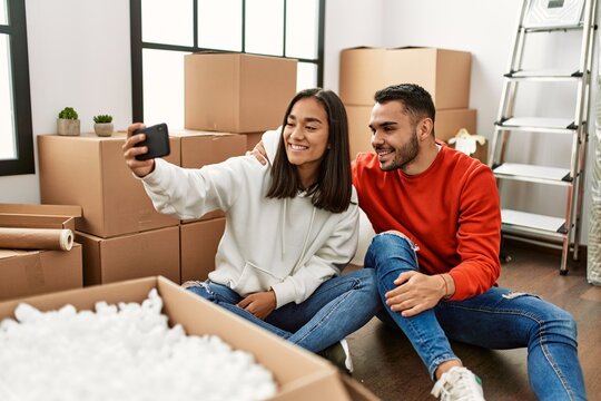 Young latin couple smiling happy make selfie by the smartphone at new home.