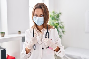 Young woman wearing doctor uniform and medical mask at clinic