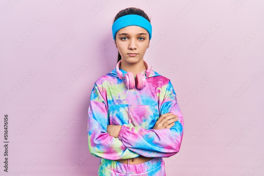 Sticker young brunette girl wearing gym clothes and headphones skeptic and nervous, disapproving expression 