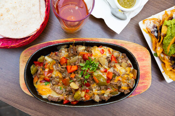 Mexican cuisine. Traditional roasted beef alambre with bacon, vegetables, cheese and sauce