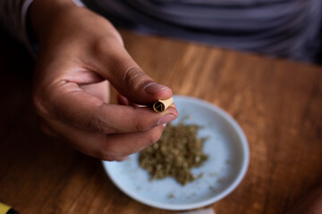 manos armando un blunt de marihuana (Cannabis). Concepto de medicina natural. © artrolopzimages