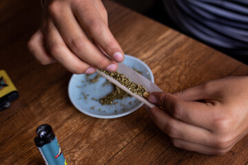 manos armando un blunt de marihuana (Cannabis). Concepto de medicina natural. © artrolopzimages