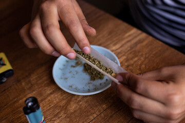 manos armando un blunt de marihuana (Cannabis). Concepto de medicina natural. © artrolopzimages