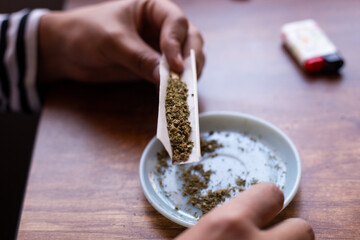 manos armando un blunt de marihuana (Cannabis). Concepto de medicina natural. © artrolopzimages