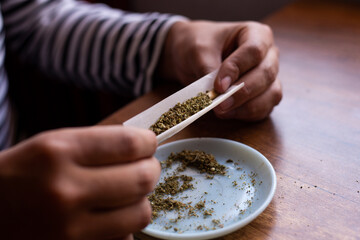 manos armando un blunt de marihuana (Cannabis). Concepto de medicina natural. © artrolopzimages