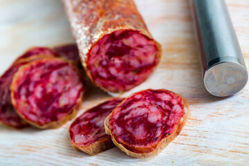 Traditional spanish dry cured pork sausage salchichon sliced on wooden background
