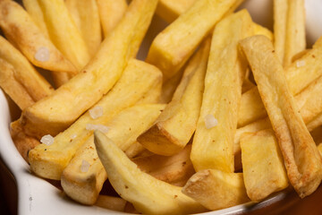 Tasty french fries on plate on bowl