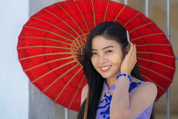 Myanmar Burmese woman with umbrella in Burmese traditional dress at Sandamuni pagoda in Mandalay