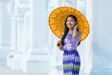 Myanmar Burmese woman with umbrella in Burmese traditional dress at Sandamuni pagoda in Mandalay