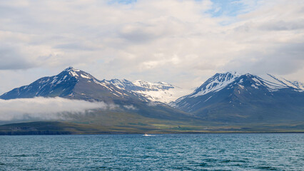 Icelandic panorama of mountains and ocean with snow on peak in the region of Akureyri