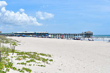 View of sandy beach at the pier in Cocoa Beach near Cape Canaveral on the Space Coast of Florida. 