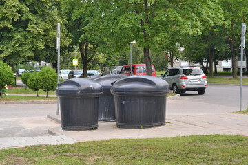 Modern garbage cans-containers in the courtyard of the house for separate waste collection - glass,...