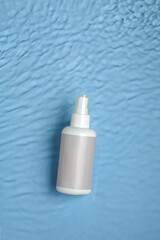 Cosmetic moisturizer with hyaluronic acid, micellar emulsion on blue water background with...
