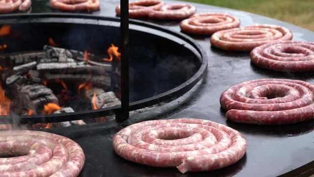 Cooking on a brasero, grilling sausage over wood fire