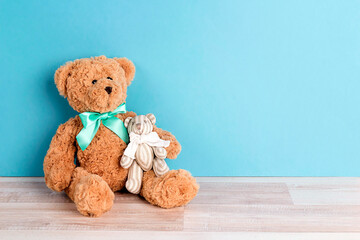 Dad toy bear with baby bear a blue background. Father's Day card with copy space.