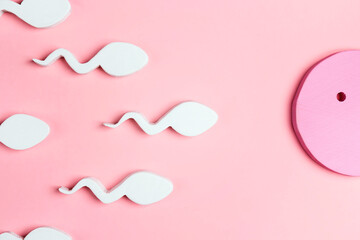 Egg and sperm on a pink background.