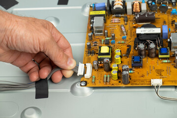 TV repair. Telemaster connects the cable to the board