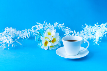 Obraz na płótnie Canvas プルメリアの花束とコーヒーと白い葉（スマイラックス）のデザイン（ブルーバック） 