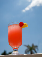 Glass of non alcoholic pink Strawberry lemonade cocktail on table or balcony at tropical resort...