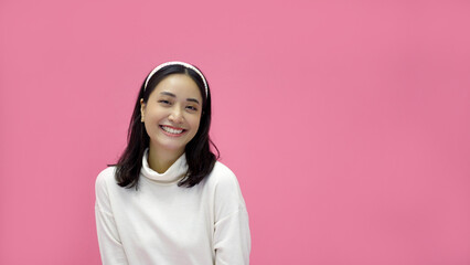 Fototapeta premium happy young woman Asian smiling and having good time, laughing, looking to side on pink background