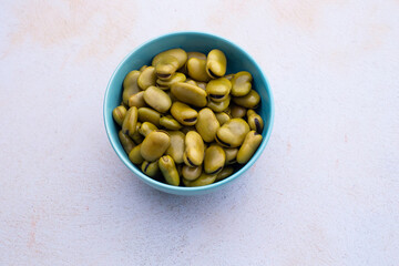 Habas hervidas servidas en un bowl con fondo claro abstracto. Concepto de alimentos.