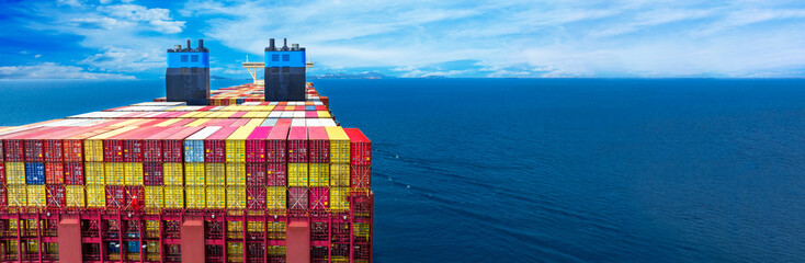 Stern of large cargo ship import export container box on the ocean sea on blue sky back ground...