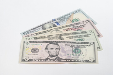 5, 20, 50, 100 dollars banknotes at different angles. Close up of dollars on white background.