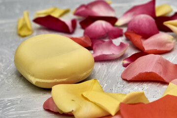 rose petals and a bar of soap on a gray textured background