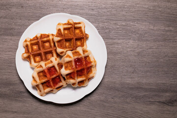 Four waffles in a white plate.and gray background.