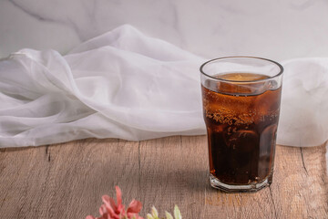 cola cola drink with ice in glass put on wooden background