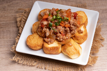 Fried tofu stir fried with ground pork and vegetables in white plate