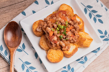 Fried tofu stir fried with ground pork and vegetables in white plate