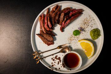 sliced beef steak on black plate food concept vintage tone.