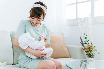 Obraz na płótnie Canvas 出産して赤ちゃんを抱っこする日本人女性（産休） 