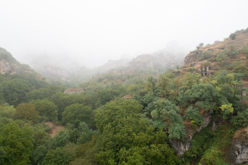 Fog view on the Khndzoresk ancient cave city in the mountain rocks. Armenia landscape attraction. Abandoned ruins in the mist. Atmospheric stock photography.