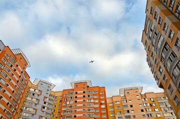 A plane is flying over the houses in the city