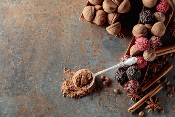 Chocolate truffles and spoon with cocoa powder.