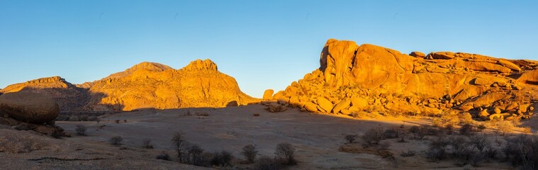 Panorama of a landscape with barren eroded granite rocks and hills in the Erongo mountains at sunset