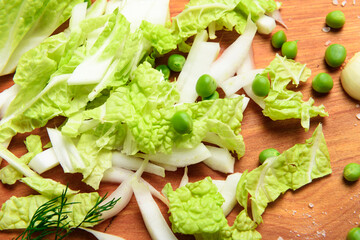 vegetables on a wooden kitchen board, dill and peas, sliced cabbage on a wood background, concept of fresh and healthy food, still life