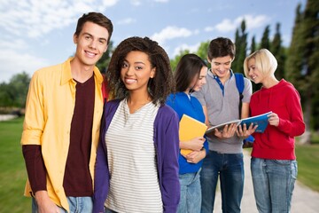 Education concept. Group smiling students with books and backpacks at walking in university campus.