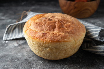 Freshly baked homemade bread with crispy crust on gray stone background