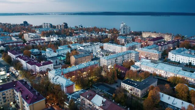 City at sunset. Aerial view of the city of Petrozavodsk and Onega lake in Russia during twilight. Drone flight over the night city