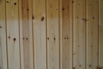 A fragment of a wall made of wooden clapboard with knots