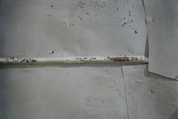 A fragment of a wall sheathed with old metal sheets painted gray