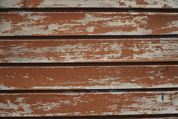 A fragment of a wall made of wooden clapboard painted in brown