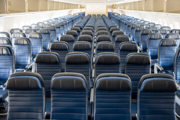 Empty cabin of a widebody commercial airplane with blue leather seats.